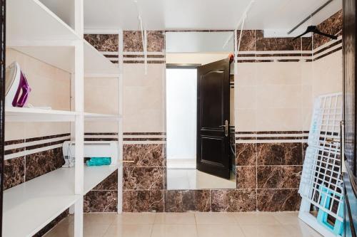 a bathroom with a toilet and a black door at Cosy 2BR Apartment in marrakech in Marrakech
