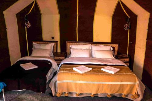 a bedroom with two beds with towels on them at Azul desert camp in Merzouga