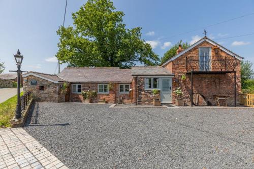 an old stone house with a gravel driveway at 2 Bed in Carreghofa oc-t32530 in Llanymynech
