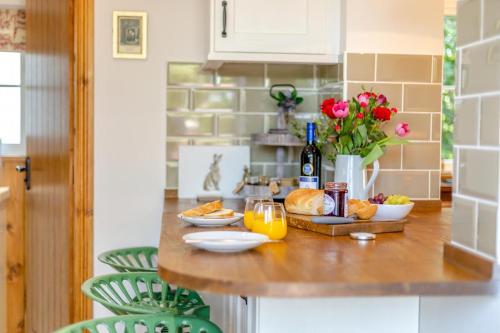 a kitchen counter with bread and orange juice and flowers at 2 Bed in Carreghofa oc-t32530 in Llanymynech