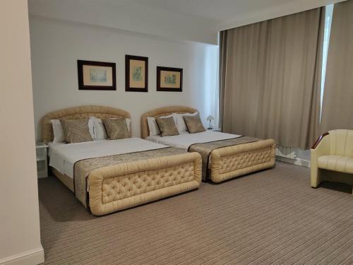 a bedroom with two beds and a couch at Hotel Mio City in Kula