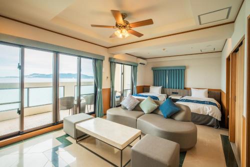a bedroom with a couch and a bed and a window at Best Western Okinawa Kouki Beach in Nago