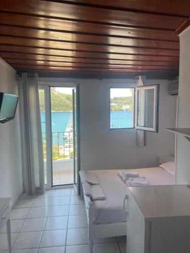 a room with two beds and a view of the ocean at Agnàntema Portside Stays Skiathos in Skiathos Town