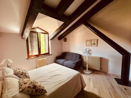 a bedroom with a bed and a chair and a window at Casa Menta in Cañícosa