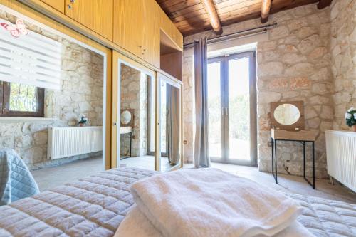 a bedroom with a bed and a stone wall at Platanus Inn Villa by "elite" in Vanáton