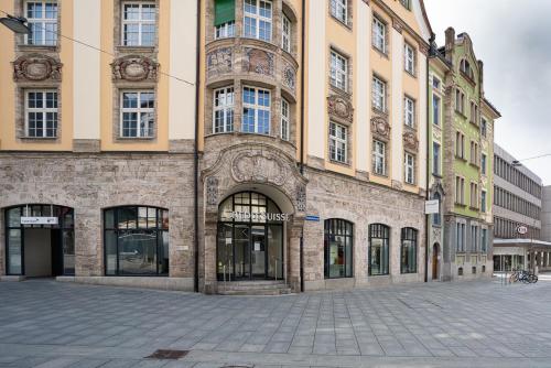 a large brick building with windows on a street at Solution-Grischun Apartments - Berninaexpress - Städterip - atemberaubende Aussicht in Chur