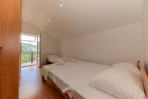 a bedroom with two beds and a large window at Apartments Golden View in Kotor