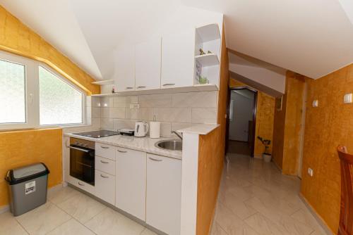 a kitchen with white cabinets and a sink at Apartments Golden View in Kotor