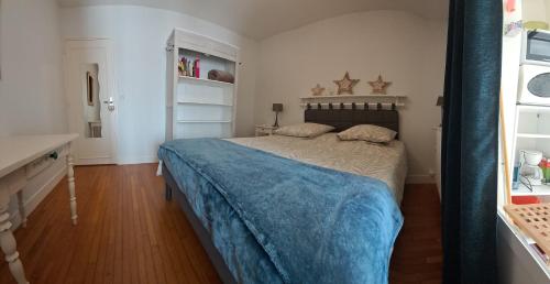 a bedroom with a bed with a blue blanket at Chez Sylvia et Patrice in Saint-Léonard