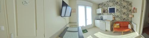 a room with a television and a desk with a chair at Chez Sylvia et Patrice in Saint-Léonard