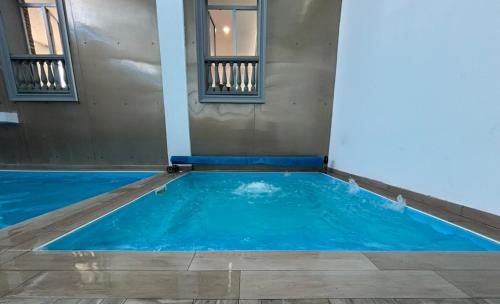 a swimming pool with blue water in a room at Hotel Mio City in Kula