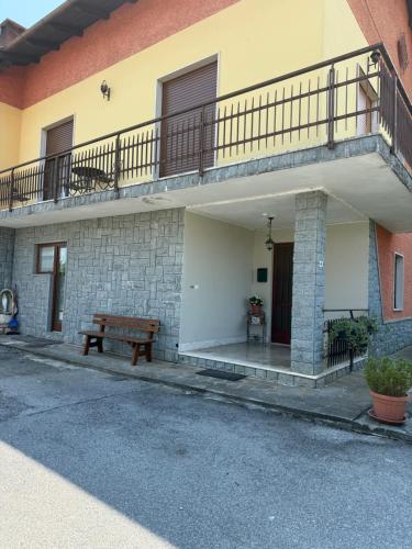 a bench sitting outside of a building with a balcony at Affittacamere La CRICOVA di Iulia in Cervasca