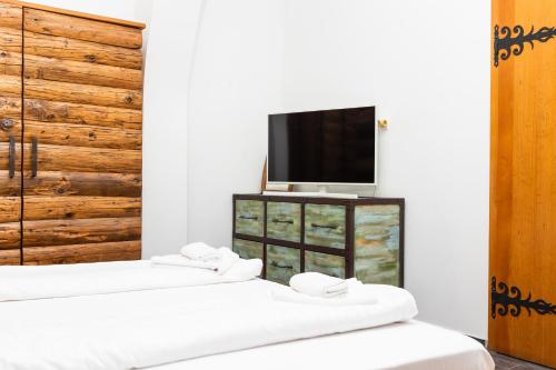 a room with three beds and a tv on a cabinet at Régi Posta Hotel és Étterem in Debrecen