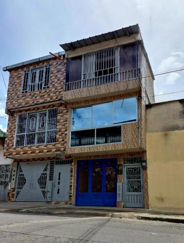 a brick building with blue doors and a balcony at Hospedaje Marina - 301 in Ibagué