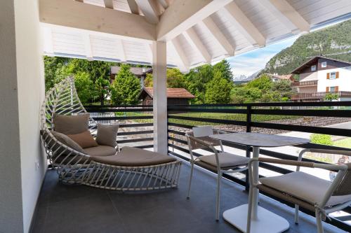 a patio with chairs and a table on a balcony at Fai le Coccole in Fai della Paganella