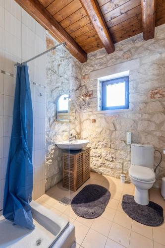 a bathroom with a toilet and a sink at Platanus Inn Villa by "elite" in Vanáton