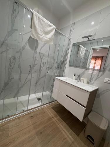 a white bathroom with a shower and a sink at Binario623 in Reggio Calabria