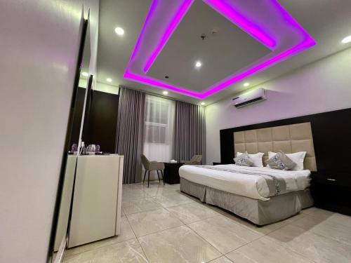 a bedroom with a bed with a purple ceiling at الأجنحة المثالية للشقق المخدومة in Taif