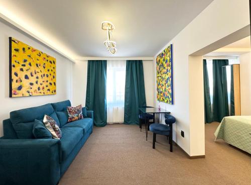 a living room with a blue couch and a bedroom at Eclectic 6 in Satu Mare