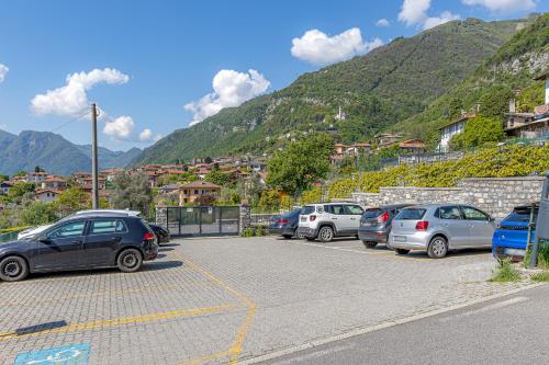 a bunch of cars parked in a parking lot with mountains at River House Lenno - Tremezzina - Como Lake in Lenno