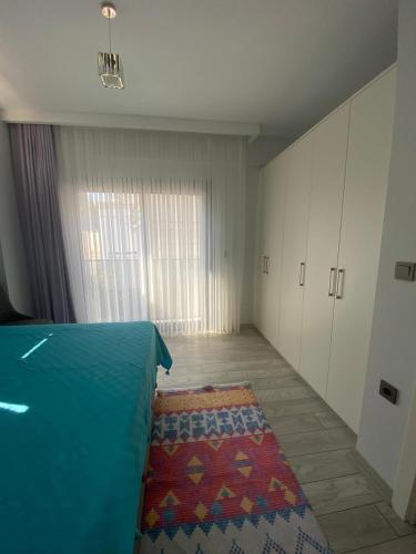 an empty room with a bed and a rug at Marina Guest House in Çeşme