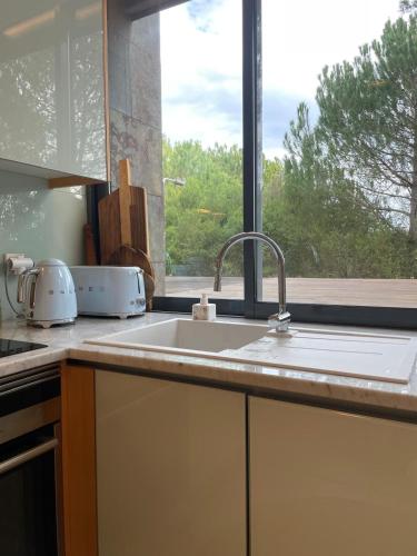 a kitchen counter with a sink and a window at Summer Villa in Troia