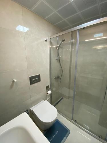 a bathroom with a shower and a toilet and a sink at Marina Guest House in Çeşme