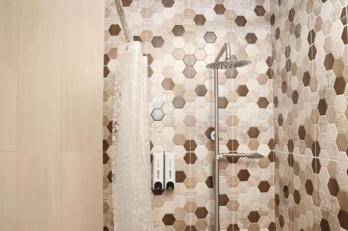 a bathroom with a shower with a mosaic tile wall at Tesaran Stepanavan Guest House, Apart Hotel in Stepʼanavan