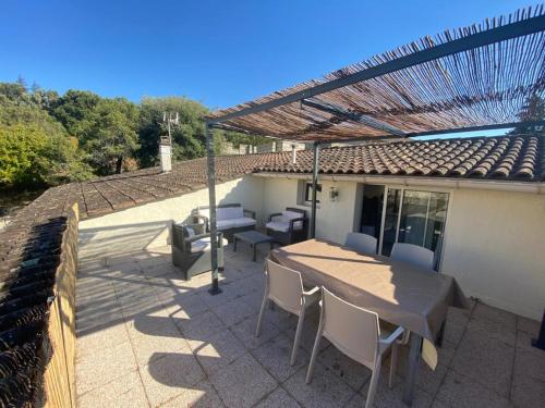 a patio with a table and chairs on a house at Gîtes Le Mas du Vieux Chêne in Salavas