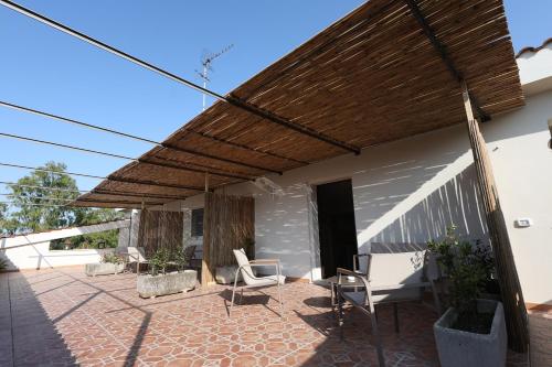 a patio with chairs and a wooden pergola at Agriturismo Pietragrande in Otranto