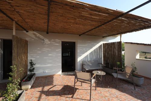 a patio with chairs and a wooden pergola at Agriturismo Pietragrande in Otranto