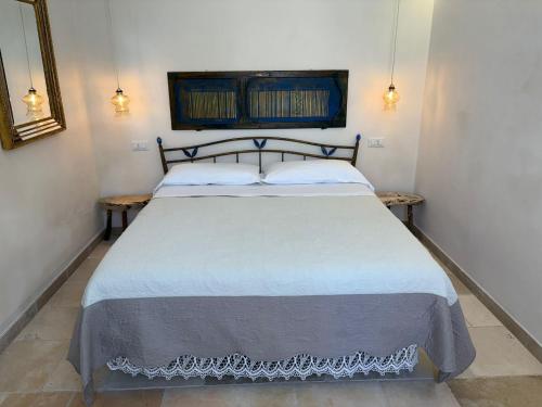 a bedroom with a white bed with two tables at Masseria Verbena Agriturismo in Monopoli