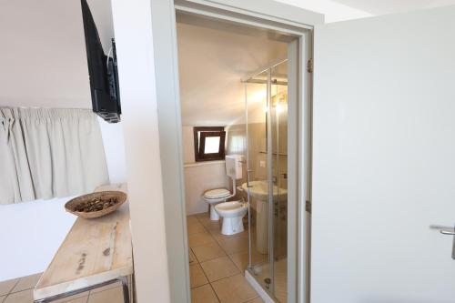 a bathroom with a toilet and a glass shower door at Agriturismo Pietragrande in Otranto