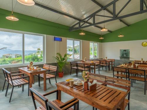 a restaurant with wooden tables and chairs and windows at The Hosteller Kodaikanal in Kodaikānāl