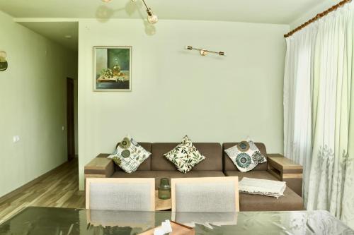 a living room with a couch and a glass table at Tesaran Stepanavan Guest House, Apart Hotel in Stepʼanavan