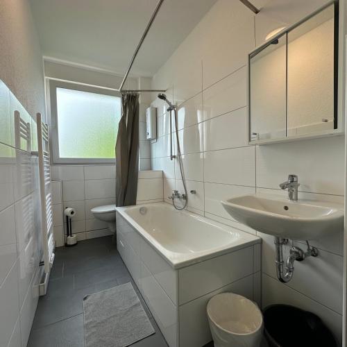 a bathroom with a sink and a tub and a toilet at WDI - Workers Apartments in Herten