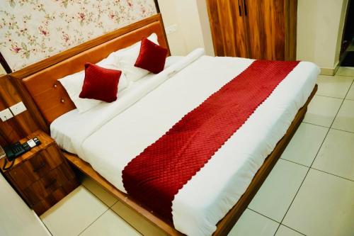ein Bett mit zwei roten Kissen darauf in der Unterkunft Sri Saaradhi Grand in Patancheru