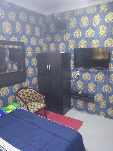 a bedroom with a bed and a tv on a wall at Peace Home in Lekki