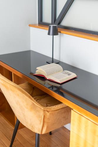 a desk with a book and a lamp on it at Deluxe Spaccanapoli in Naples