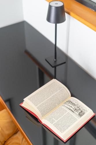 an open book on a table with a lamp at Deluxe Spaccanapoli in Naples