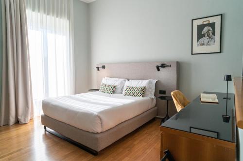 a bedroom with a bed with a desk and a bed sidx sidx sidx at Deluxe Spaccanapoli in Naples