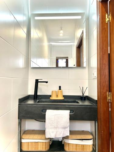a bathroom with a black sink and a mirror at CENTER APARTMENT Mazagón in Mazagón