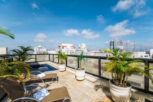 a balcony with palm trees and a swimming pool at Transamerica Executive Bela Cintra (Paulista) in Sao Paulo