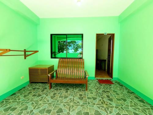 a living room with a bench and a flat screen tv at Resort Manuela Panglao in Panglao