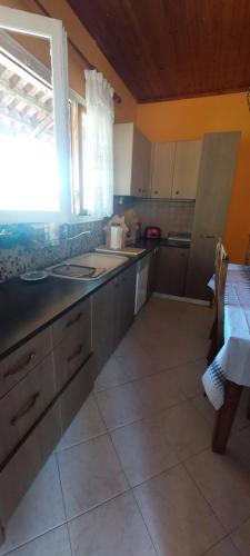 a kitchen with a sink and a table and a window at Cute House with mountain views 
