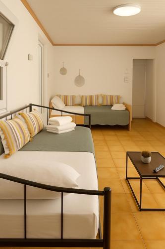 a room with two beds and a table at Kiki House in Nea Potidaea