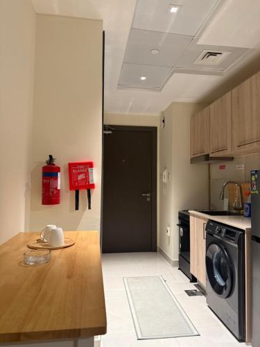 a kitchen with a table and a black door at One Click in Dubai