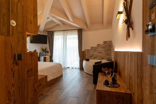 a hotel room with a bed and a couch at Fai le Coccole in Fai della Paganella
