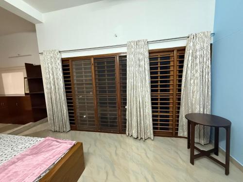 a bedroom with a bed and a window with blinds at Bindas in Trivandrum