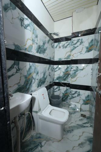 a bathroom with a toilet and a sink at Hotel Shri Balaji Dham, Family Room Near Mathura Railway Station in Mathura